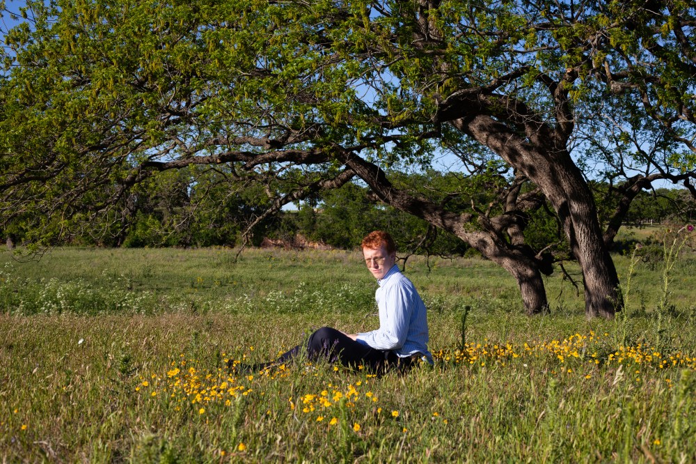 Photo by Brianna Caleri, man sitting in wild flowers, Texas Hill County, model Jacob Searles